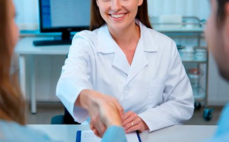 Женщина и мужчина здороваются с врачом на приёме